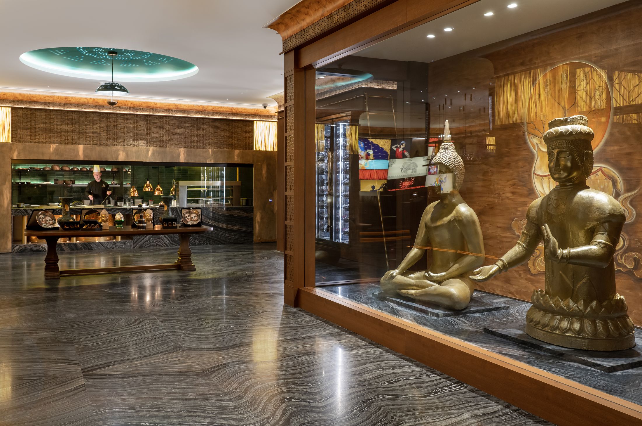 Marble corridor with golden statues leading to the open kitchen